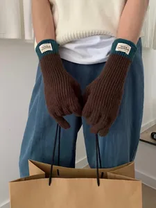 Close-up of winter knit touchscreen gloves with brown palm and green cuff detail