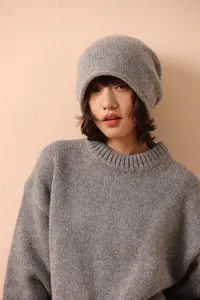 Close-up of gray 100% wool knit beanie showing soft textured mixed-color yarn details