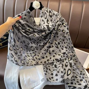 Détail d'une écharpe léopard grise avec dorures et texture douce en coton et lin