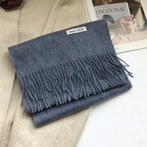 Close-up of a premium dark blue 100% Australian wool scarf with tassels and material tag