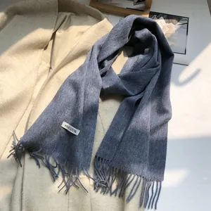 Close-up of 100% Australian wool scarf in blue with long fringe detail and fabric label