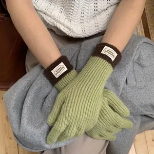 Knitted touch-screen gloves in sage green and brown with minimalist woven wrist label