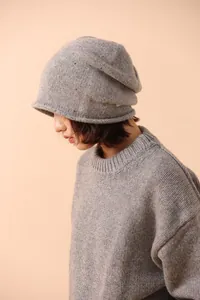 Detail of light gray pure wool knit beanie showing soft texture and ribbed patterns
