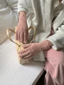 Pink rib-knit winter gloves with gold button detail and soft thermal wool texture