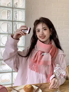 Nahaufnahme eines rosa karierten Premium-Wollschals mit langen Fransen und gewebtem Etikett