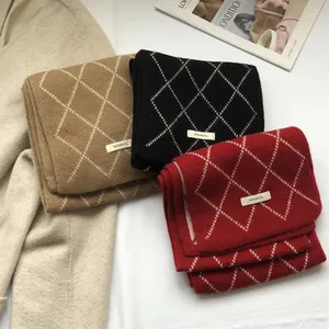 Macro shot of 100% wool scarves in three colors with classic diamond pattern and tags