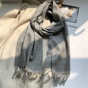 Close-up of gray 100% Australian wool scarf with tassels and white fabric care label