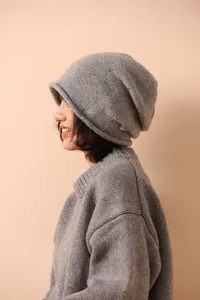 Detail of grey wool knit beanie and matching sweater set on a model for winter warmth