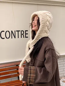 Detail of chunky cable-knit cream Balaclava hood showing thick wool texture and warm neck cover