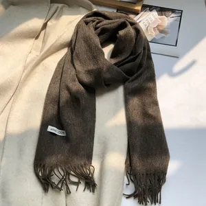 Detail view of the soft 100% Australian wool texture and fringe on dark brown scarf