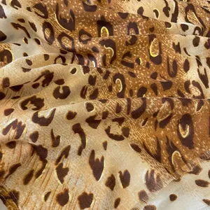 Détail d'une écharpe en coton à imprimé léopard avec dorure élégante et tons caramel chauds