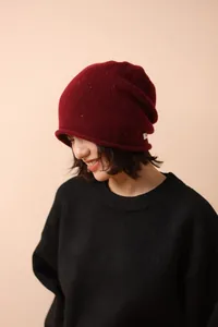 Detailed knit texture of burgundy wool beanie with colorful nep yarn and side patch