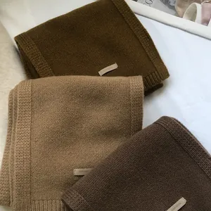 Texture detail of three 100% Australian wool scarves with ribbing and fabric labels