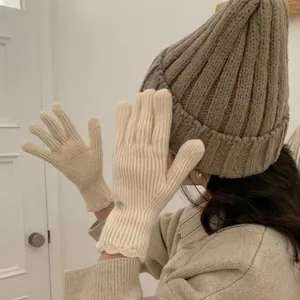 Cream knit thermal gloves for women featuring ribbed texture and delicate lace trim cuff
