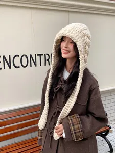 Detail of chunky knit cream balaclava hood showing thick cable texture and long straps