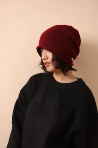 Detailed side view of wine red wool knit beanie with colorful speckled yarn texture