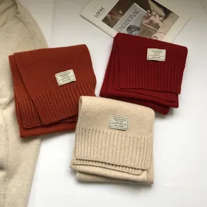 Close-up of 100% Australian wool scarves showing premium knit texture and woven labels