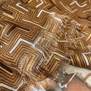 Close-up of geometric pattern scarf with metallic threads and fringe edge detail