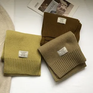 Detailed close-up of 100% Australian wool scarves in olive, brown, and beige tones