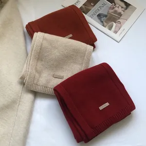 Detail of 100% Australian wool scarves showing knitted texture and leather wool labels