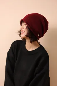 Detail view of burgundy 100% wool knit beanie with subtle flecks and rolled edge