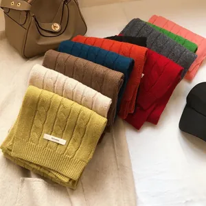 Detailed cable knit texture of colorful 100% wool scarves in a variety of vibrant shades