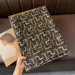Detail of geometric pattern scarf with metallic gold print and fine fringe edges