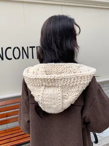 Detailed back view of chunky cable knit balaclava in cream white on female model