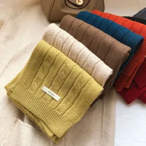 Macro shot of 100% wool knitted scarves in multiple colors showing chunky cable knit texture