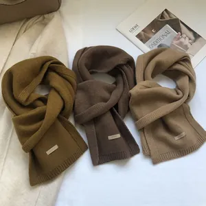 Detailed view of three 100% Australian wool scarves in green, brown and camel colors