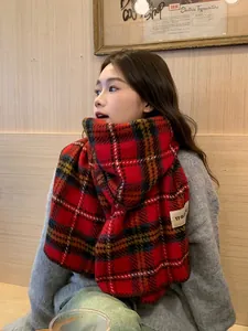 Détail de l'écharpe à carreaux rouges style cachemire avec motif tartan et étiquette tissée