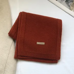 Detail of 100% Australian wool scarf featuring a woven label and knit texture