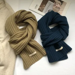 Detailed close-up of thick 100% wool ribbed scarves in camel and navy blue colors