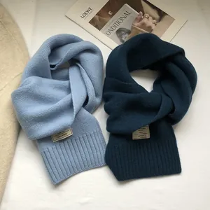 Detailed close-up of light blue and dark teal 100% wool scarves in rib knit texture