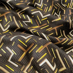 Macro view of geometric cotton scarf fabric with metallic gold foil and fabric texture
