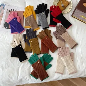 Detailed view of colorful knitted winter gloves with ribbed cuffs and gold button accent