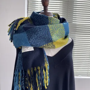 Detailed texture of thick blue and yellow plaid cashmere-feel scarf with long tassels