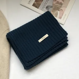 Detail of blue ribbed 100% pure wool scarf showing soft knit texture and material tag