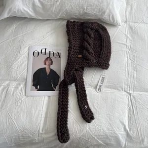 Deep brown chunky knit balaclava with side cable patterns and long straps