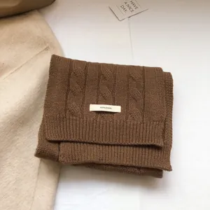 Macro detail of brown 100% wool scarf showing high-quality cable knit texture