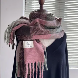 Close-up of thick plaid scarf with soft tassels and woven brand label detail