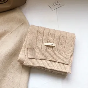 Detail of cable knit texture on a 100 percent wool winter scarf in beige oatmeal color