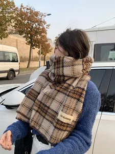 Gros plan sur l'écharpe à carreaux marron avec étiquette sur tissu doux aspect cachemire