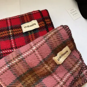 Gros plan d'écharpes épaisses à carreaux rouge-noir et rose-brun avec de fines franges