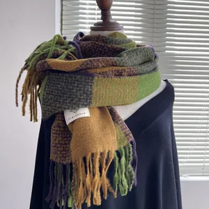 Detail of soft plaid scarf with tassels in green, yellow and purple on a mannequin