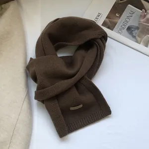 Detail view of 100% Australian wool scarf featuring dark brown knit texture and fabric label