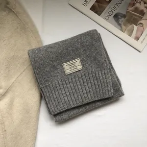 Close-up of 100% Australian wool scarf label showing soft knitted grey fabric texture