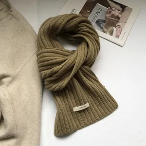 Macro shot of 100% pure wool thick rib-knit scarf in brown camel with striped texture