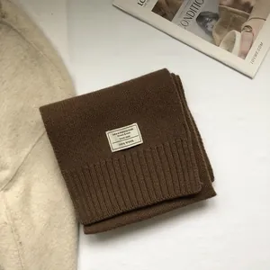 Detail of 100% Australian wool scarf featuring a woven label and rib-knit edge