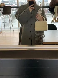 Chic cream faux fur handbag paired with a plaid scarf and grey coat for winter